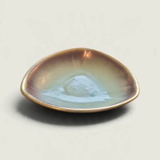 Vintage triangular German pottery bowl with a pale blue-green centre and glossy brown and amber rim, viewed from a low angle.