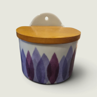 White ceramic wall storage jar with purple leaf decoration, wooden lid and a hanging hole.