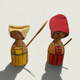 Pair of wooden egg cups with smiling figure covers, red and yellow painted aprons, fabric hats and wooden spoons.